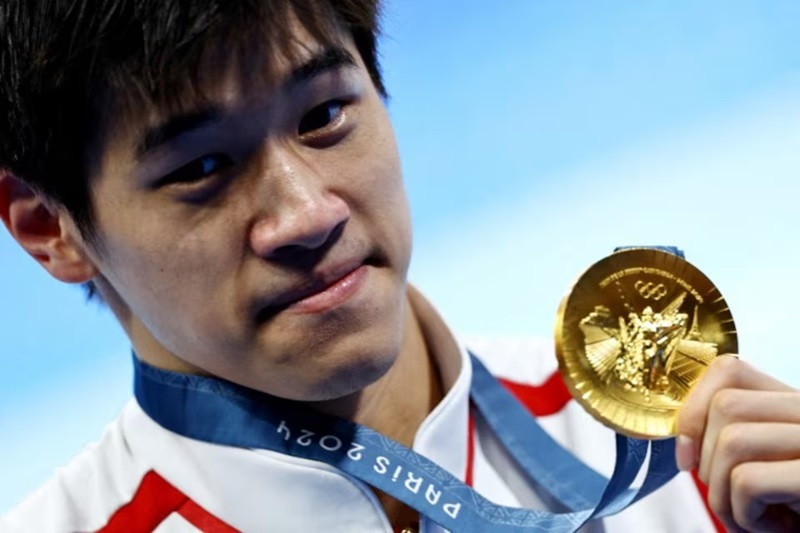 Gold medallist Zhanle Pan of China celebrates after winning the race and setting a new world record. PHOTO: REUTERS